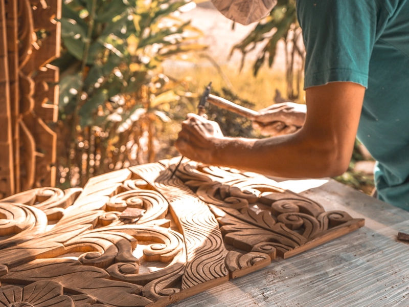 Wood carver in process, close up carving details on reclaimed teak headboard