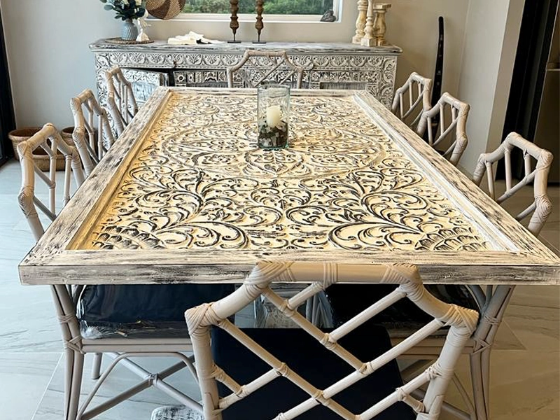 Hand-carved teak dining table with matching sideboard in a modern home